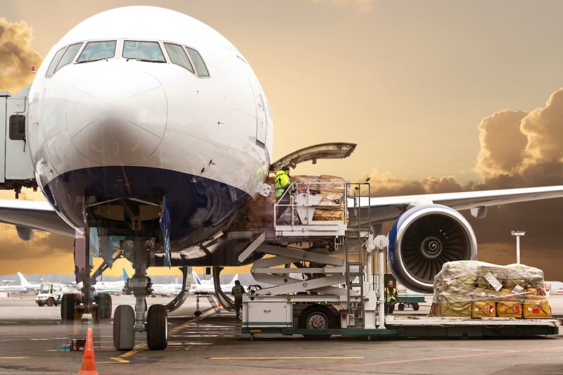 Loading cargo on the plane in airport, view through window